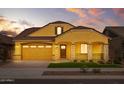 Beautiful yellow home with a two-car garage and well-manicured lawn at 22852 E Thornton Rd, Queen Creek, AZ 85142