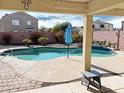 Inviting kidney-shaped pool with a patio and covered seating area at 5725 E Good Pasture Ln, Florence, AZ 85132