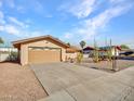 House exterior featuring a tan facade and a two-car garage at 6554 E Dallas St, Mesa, AZ 85205