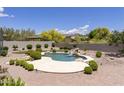 Inviting kidney-shaped pool with a waterfall feature and spacious patio at 11175 N 121St Way, Scottsdale, AZ 85259