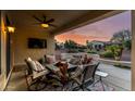 Covered patio with ceiling fan and TV, furnished with comfortable seating around a fire pit, ideal for relaxation at 12942 W Sola Dr, Sun City West, AZ 85375