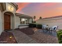 Inviting front entrance featuring a cozy patio area with comfortable seating and a manicured walkway to the front door at 12942 W Sola Dr, Sun City West, AZ 85375