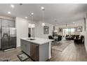 Open concept kitchen with island and breakfast bar, flows into living room at 14627 W Valentine St, Surprise, AZ 85379