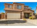 Two-story house with a beige exterior, attached garage, and desert landscaping at 33602 N Cobble Stone Dr, San Tan Valley, AZ 85143