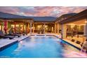 Inviting pool area with expansive patio and luxurious lounge seating at 9968 W Jj Ranch Rd, Peoria, AZ 85383