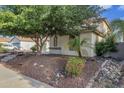 Side view of a two-story house with mature trees and rock landscaping at 13616 W San Miguel Ave, Litchfield Park, AZ 85340