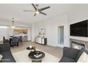 Open-concept living room with a fireplace, a ceiling fan, and a view of the kitchen at 19777 N 76Th St # 3246, Scottsdale, AZ 85255