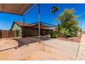 Exterior showcasing a covered carport, desert landscaping, and a spacious driveway for additional parking at 548 N 82Nd St, Mesa, AZ 85207