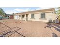 Tan colored house exterior with a driveway, landscaping, and basketball hoop at 6130 W Monte Vista Rd, Phoenix, AZ 85035