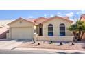 Tan house with tile roof, two-car garage, and landscaped front yard at 6877 S Oakmont Dr, Chandler, AZ 85249