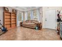 Living room with tiled floors, a sofa, and wooden shelves at 6962 W Glenn Dr, Glendale, AZ 85303