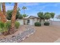 Landscaped front yard with a rock garden and mature trees at 947 N 85Th Pl, Scottsdale, AZ 85257