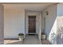 Dark wood front door with a welcoming mat and brick facade at 947 N 85Th Pl, Scottsdale, AZ 85257