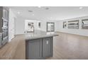 Open floor plan: Kitchen island with modern fixtures and eat-in bar overlooks the bright living space at 17815 W Denton Ave, Litchfield Park, AZ 85340