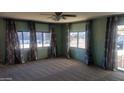 Spacious living room with light green walls, patterned curtains, and carpeted floor at 201 S Greenfield Rd # 16, Mesa, AZ 85206