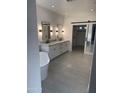 Modern bathroom with double vanity, free-standing tub, and walk-in closet at 22335 N 77Th Pl, Scottsdale, AZ 85255