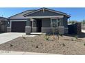 Inviting single-story home with a covered entry, a two-car garage, and xeriscaped front yard at 22563 W Pontiac Dr, Surprise, AZ 85387