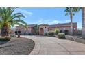 Impressive exterior of a single-story house with a stone facade and palm trees at 2625 W Desert Hills Dr, Phoenix, AZ 85086