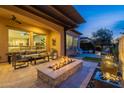 Cozy back patio featuring comfortable seating, a modern fire pit, and a tranquil water feature at 290 E Tangerine Path, Queen Creek, AZ 85140
