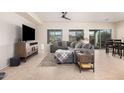 Spacious living room with tile flooring, a comfortable sectional sofa, and a ceiling fan at 6546 W Georgetown Way, Florence, AZ 85132