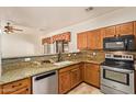 Kitchen features granite counters, wood cabinets and stainless appliances at 7046 W Mercer Ln, Peoria, AZ 85345