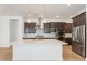 Modern kitchen boasts a large island, stainless steel appliances, and dark wood cabinets at 1113 E La Mirada Dr, Phoenix, AZ 85042