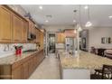 Open concept kitchen with granite island and breakfast bar at 17679 W Redwood Ln, Goodyear, AZ 85338