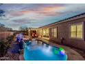 Inviting pool and spa with water feature and lighting at 17679 W Redwood Ln, Goodyear, AZ 85338