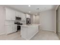 Modern kitchen features white cabinets, stainless steel appliances, and a functional center island with sink at 2917 N Evergreen St, Buckeye, AZ 85396