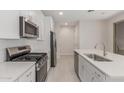 Stylish kitchen showcasing stainless steel appliances, white cabinets, island sink and subway tile backsplash at 2917 N Evergreen St, Buckeye, AZ 85396