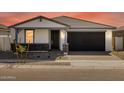 Inviting exterior featuring a stone facade, covered porch, and a well-maintained landscape at 4041 S 176Th Dr, Goodyear, AZ 85338