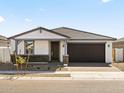 Charming single-story home featuring a dark brown garage door and neutral-toned stucco exterior at 4041 S 176Th Dr, Goodyear, AZ 85338