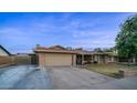 Brick ranch house with a 2-car garage and landscaped yard at 4939 W Carol Ave, Glendale, AZ 85302