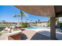Outdoor kitchen and a covered patio overlooking the sparkling pool and green golf course at 6178 W Quail Ave, Glendale, AZ 85308