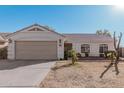 Single-story home with a two-car garage and desert landscaping at 9041 W Virginia Ave, Phoenix, AZ 85037