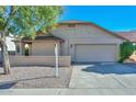 House exterior showcasing a two-car garage and desert landscaping at 10405 N 65Th Dr, Glendale, AZ 85302