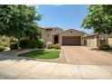 Single-story home with a two-car garage and landscaped front yard at 15677 W Almeria Rd, Goodyear, AZ 85395