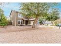 Home with xeriscaping front yard featuring a mature shade tree and two-car garage at 415 W Midland Ln, Gilbert, AZ 85233