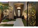 Inviting entryway featuring a wrought iron gate and pathway to the front door at 42406 N Long Cove Way, Anthem, AZ 85086