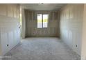 Unfinished bedroom with white drywall, a large window and doorway at 5510 W Paseo Way, Laveen, AZ 85339