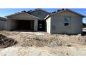 New construction gray home with attached garage and front yard with dirt and concrete driveway at 5510 W Paseo Way, Laveen, AZ 85339