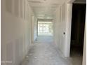 Unfinished hallway with white drywall and view to back yard through sliding glass doors at 5510 W Paseo Way, Laveen, AZ 85339