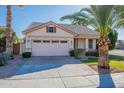 Single-story house with a two-car garage and palm trees in the front at 1491 W Armstrong Way, Chandler, AZ 85286