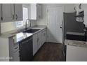 Modern kitchen with white cabinets, granite counters, and black appliances at 4409 E Darrel Rd, Phoenix, AZ 85042