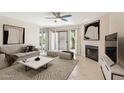 Cozy living room with a fireplace, plush seating, decorative artwork and sliding doors leading to the outdoors at 5998 N 78Th St # 116, Scottsdale, AZ 85250