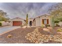 One-story house with drought-tolerant landscaping and a three-car garage at 32159 N 127Th Dr, Peoria, AZ 85383