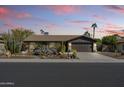 Single-story home with desert landscaping and a two-car garage at 14415 N 62Nd St, Scottsdale, AZ 85254