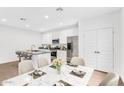Bright kitchen features stainless steel appliances, granite countertops, and a dining area with a marble table at 14670 W Sand Hills Rd, Surprise, AZ 85387