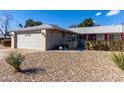 House exterior with a two-car garage and rock landscaping at 14818 N 103Rd Ave, Sun City, AZ 85351