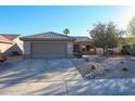 Single-story home with desert landscaping and two-car garage at 17561 N Saddle Ridge Dr, Surprise, AZ 85374